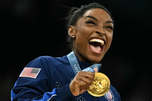 US' Simone Biles poses with the gold medal during the podium ceremony for the artistic gymnastics women's team final 