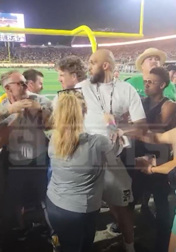 Derrick White is held back by security after being hit in the head at the Colorado-Colorado State game on Sept. 14, 2024.