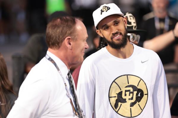 Derrick White (r.) talks with Colorado athletic director Rick George (l.) during a previous Colorado football game on Aug. 29, 2024.