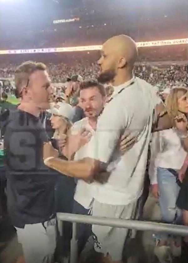 Derrick White is held back by fans after being hit in the head at the Colorado-Colorado State game on Sept. 14, 2024.